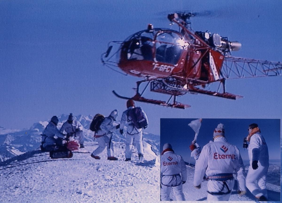 Hélicoptère transportant une immense bâche publicitaire Eternit lors d’un événement promotionnel, symbole de visibilité aérienne et d’impact spectaculaire.