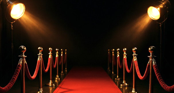 Tapis rouge et projecteurs symbolisant l’élégance et la mise en scène d’un événement d’exception – AEK21 Event.